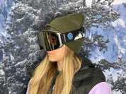 Woman wearing a pair of STAGE Cusotm Ski Goggles featuring the Alaska Avalanche Information Center logo on the STAGE Propnetic Magnetic Ski goggles